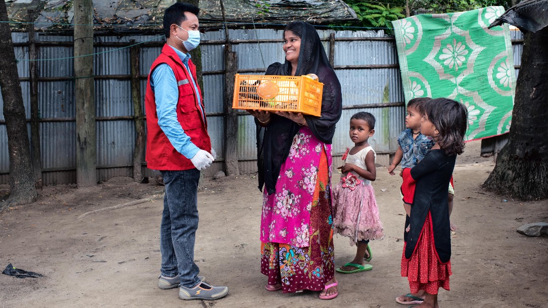 Mohammed arrives with a food package in the house of Monowara in Bangladesh