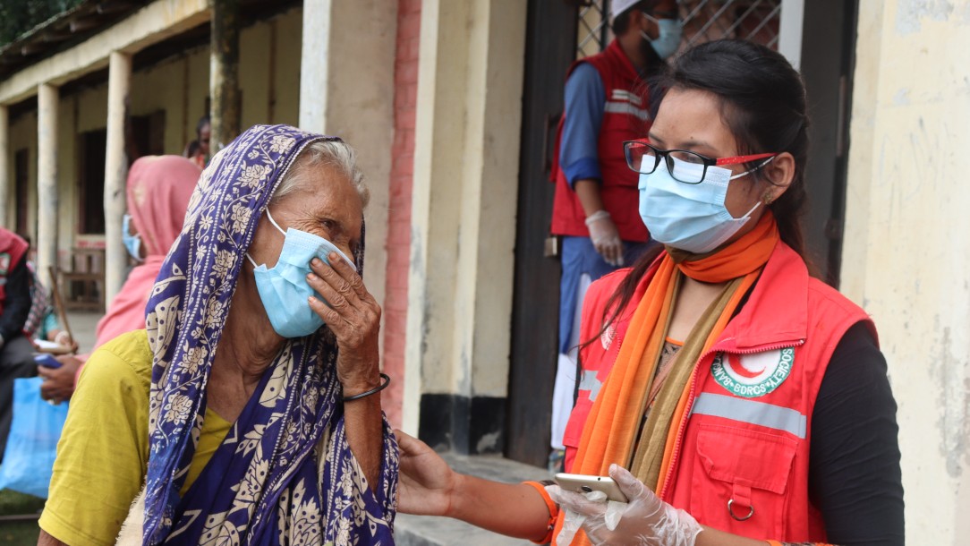 A volunteer from the Bangladesh Red Crescent speaks to a woman 