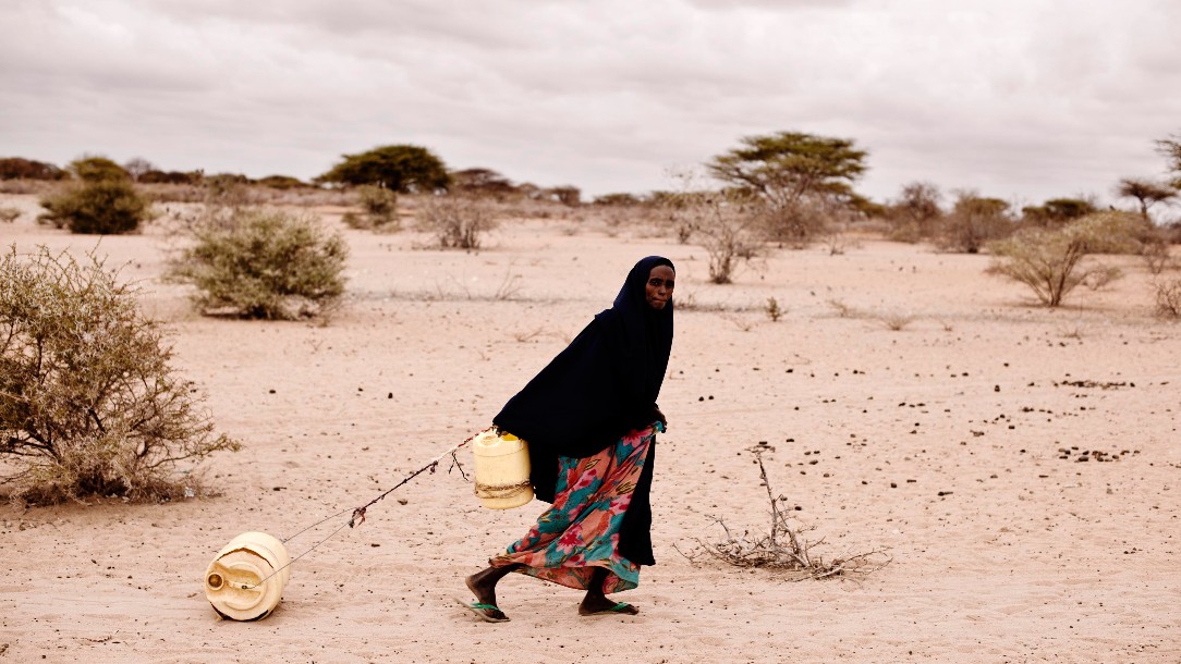 A woman fetches water for her family at a well in Elhado, Djibouti. Every day, she travels 2-3 times a day, 2 km each way. There are two wells operating in the area, which has vastly increased the population of the city.