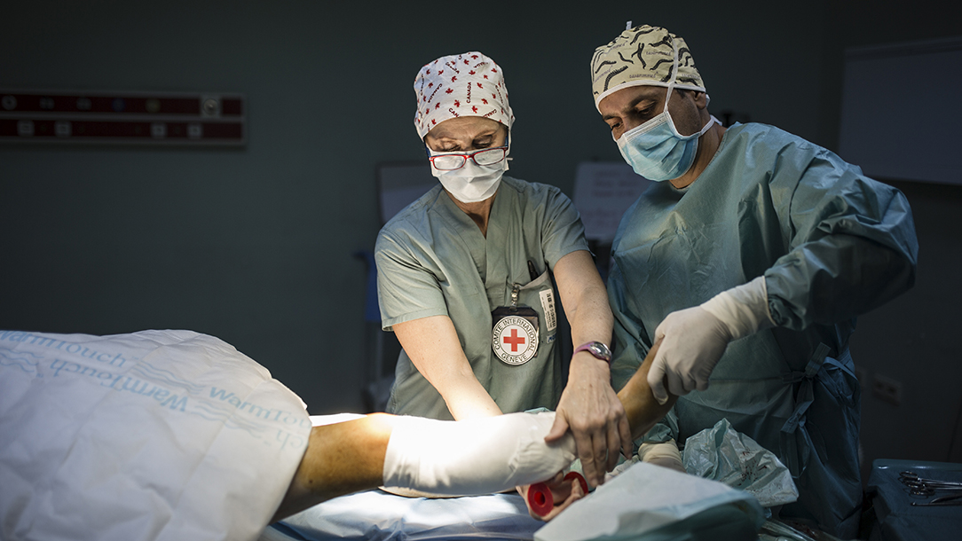  An operating theatre nurse wearing a uniform bearing the red cross emblem puts a bandage on the operated wounds of a patient who was injured in Mosul. 