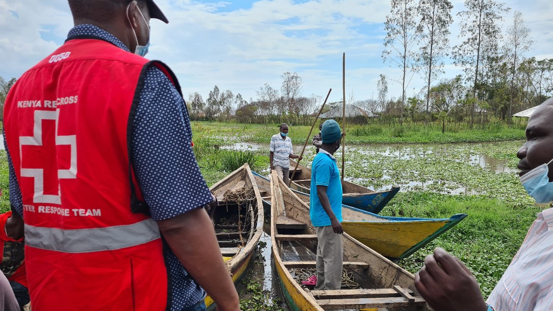 A member of the Kenya Red Cross's disaster response team looks over flooded land
