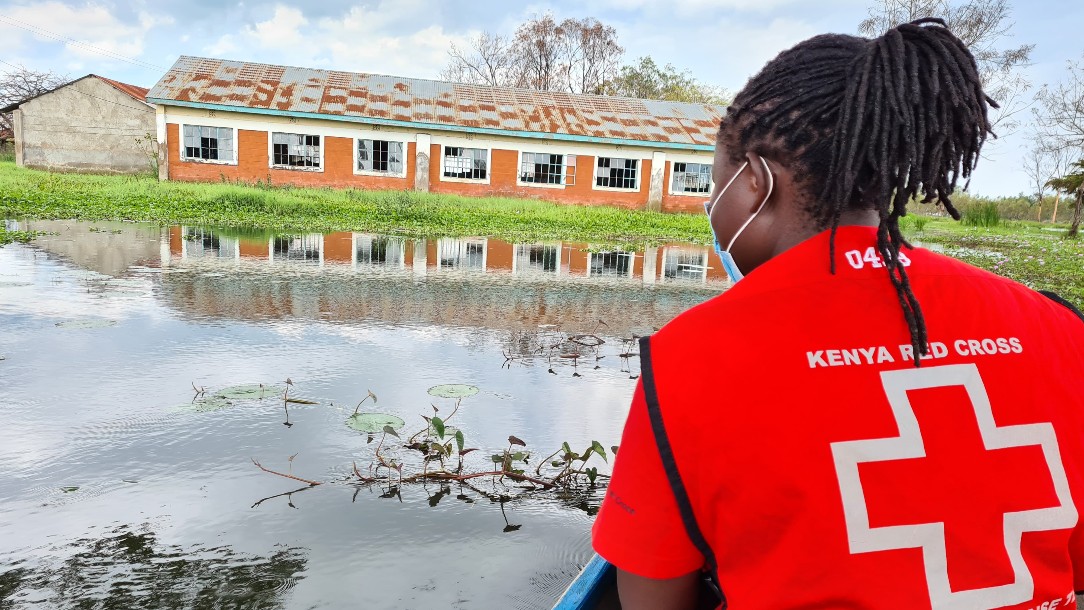 A person from the Kenya Red Cross looks out at floodwater 