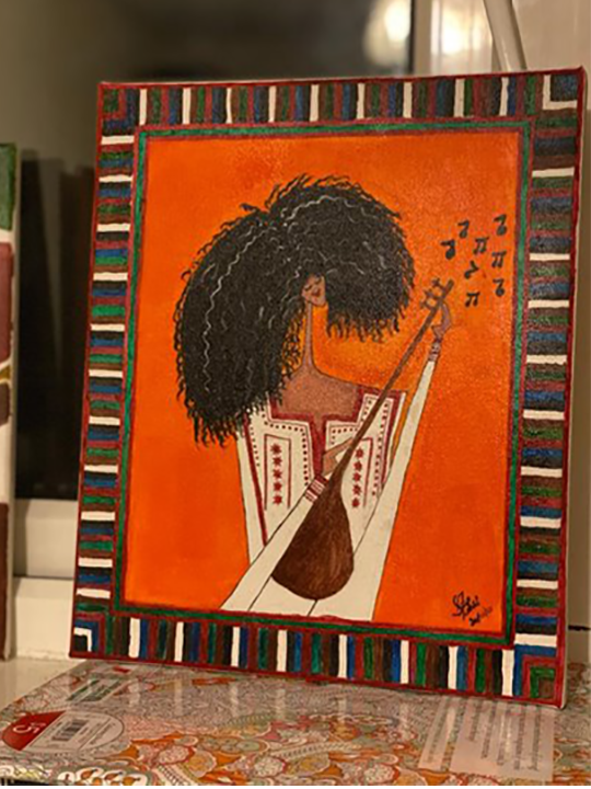 A painting of an African woman playing a guitar by a young woman refugee.