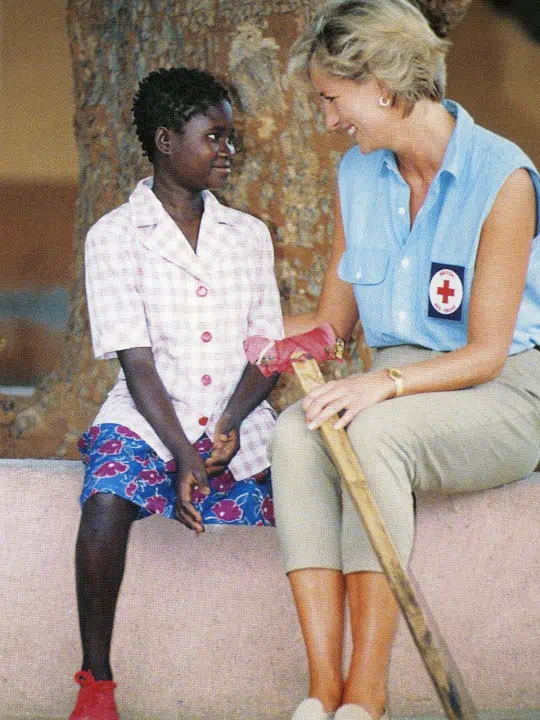 In Angola, Princess Diana speaks to a landmine survivor who lost her leg.