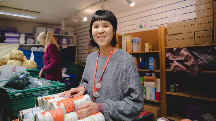 Gloria Ho, a British Red Cross staff member at the Hackney refugee centre in London, stands with supplies to give to refugees and asylum seekers.
