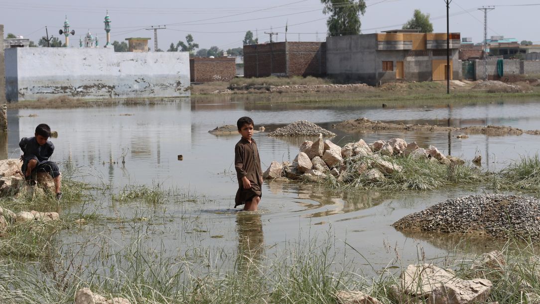 Children stand in flood water in Pakistan after devastating floods