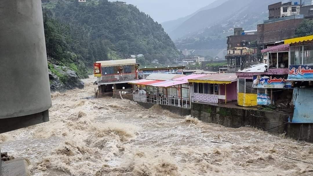 Fast-moving water is seen flooding through a built-up area in Pakistan