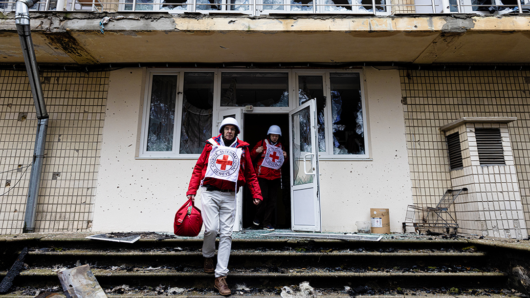 ICRC members leave building badly damaged during the conflict in Ukraine.