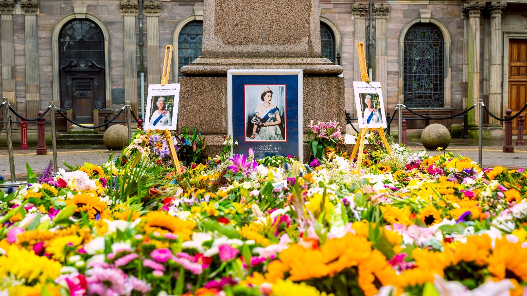 A portrait of Queen Elizabeth II stands behind a sea of floral tributes left for Her Majesty on the day of her funeral 