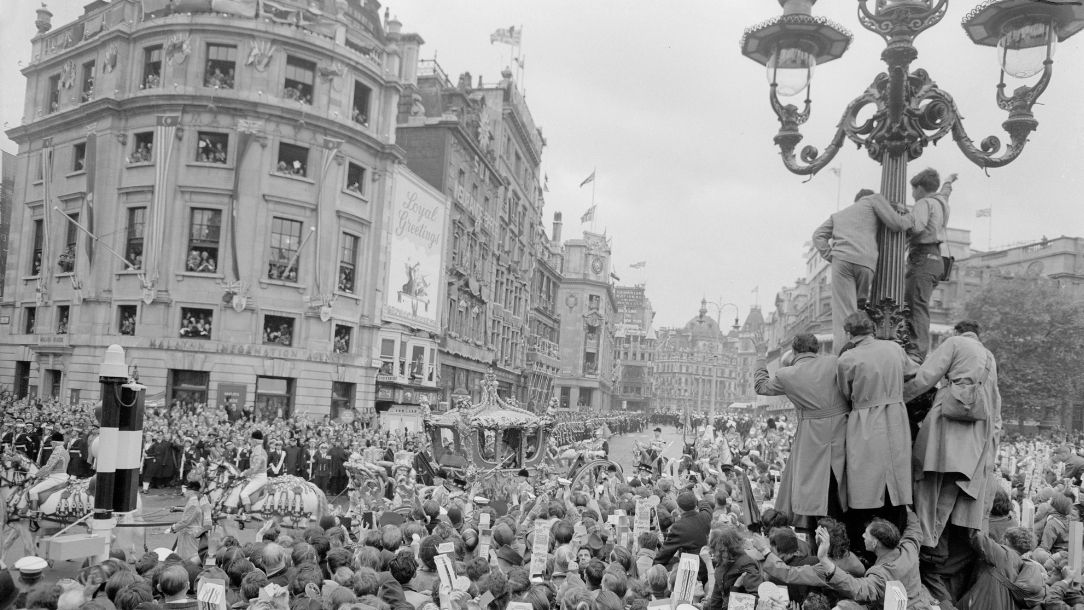 A black and white photo from 1952 showing crowds gathered in Trafalgar Square, London for the Queen's coronation.