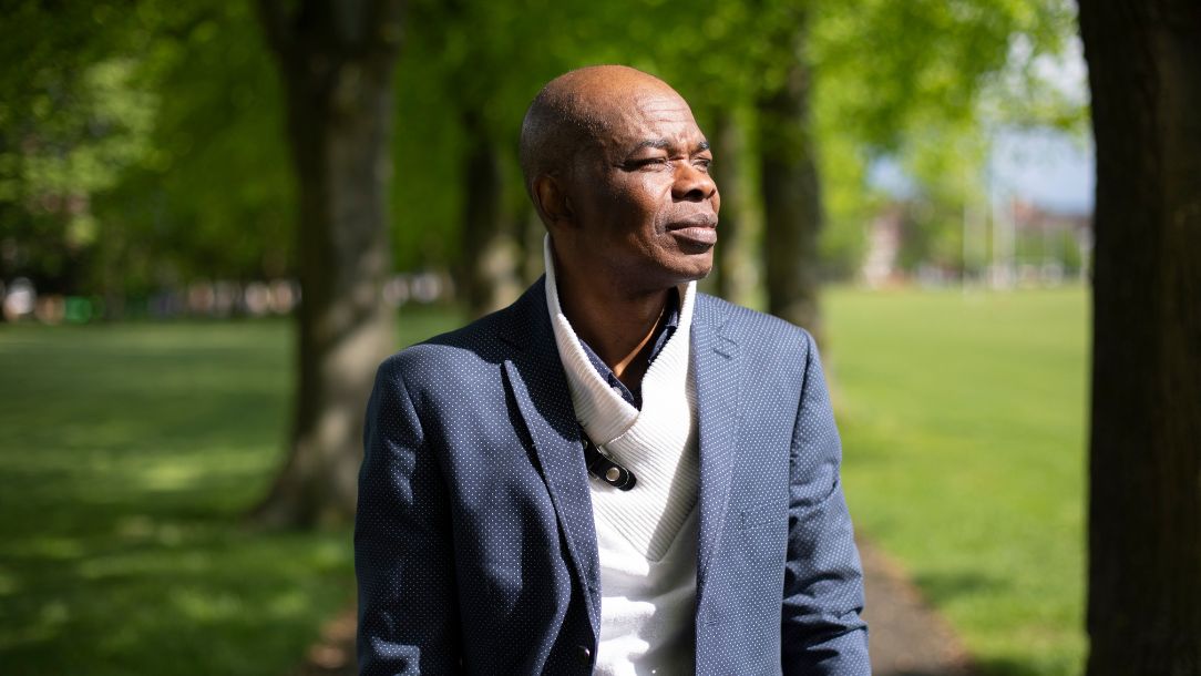 Ricardo, an ambassador from the British Red Cross VOICES network, stands in a park looking thoughtful.