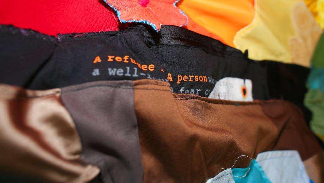 Details of a pride flag made out of red, orange, yellow, black and brown rags.
