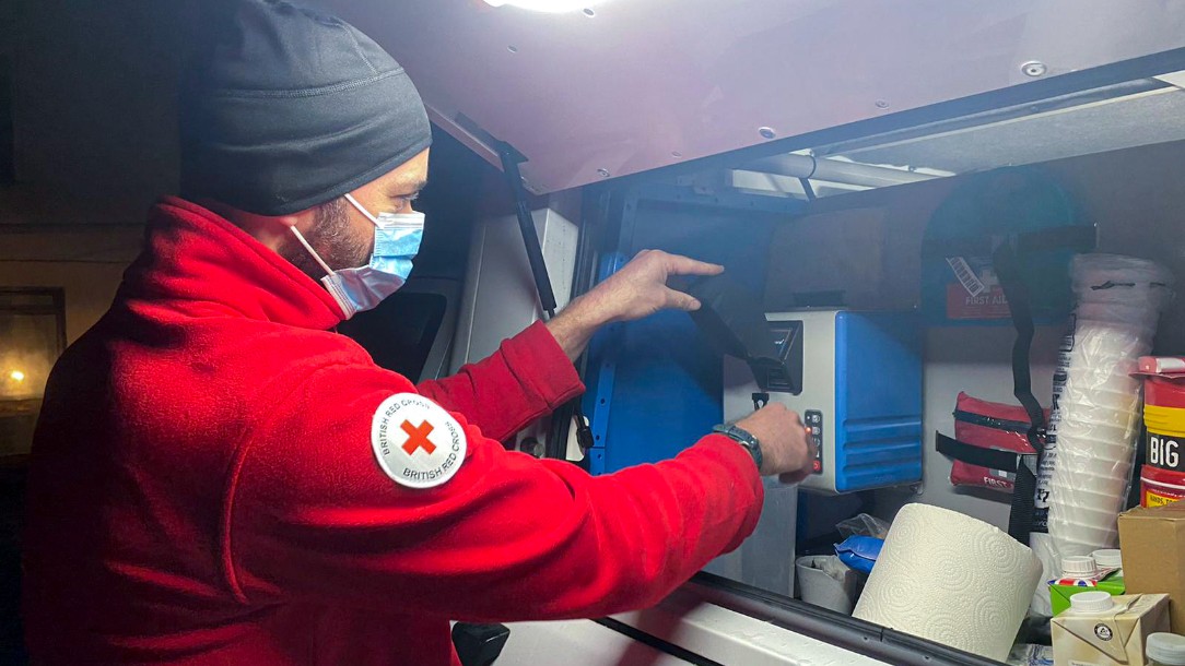 A Red Cross volunteer uses the car boiler to give hot water to a care home in South Wales during Storm Eunice