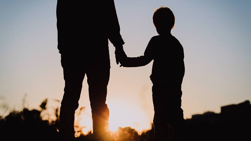 support-man-and-child-holding-hands-in-silhouette-looking-at-sunset (1)
