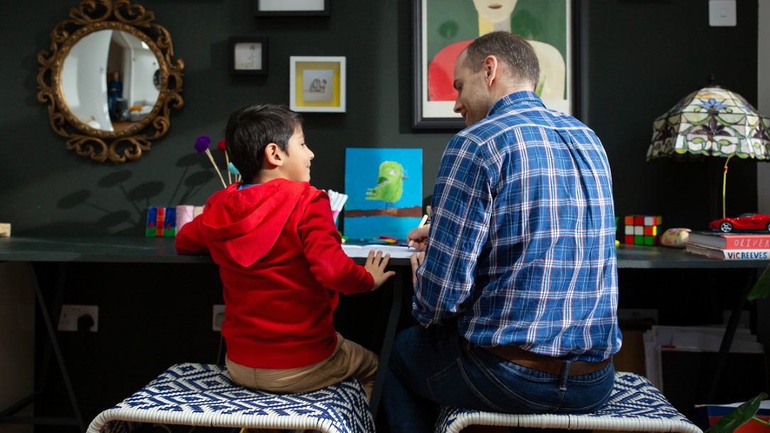 Father and child talking to each other in front of a computer