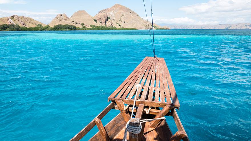 A boat in the sea near some islands. 