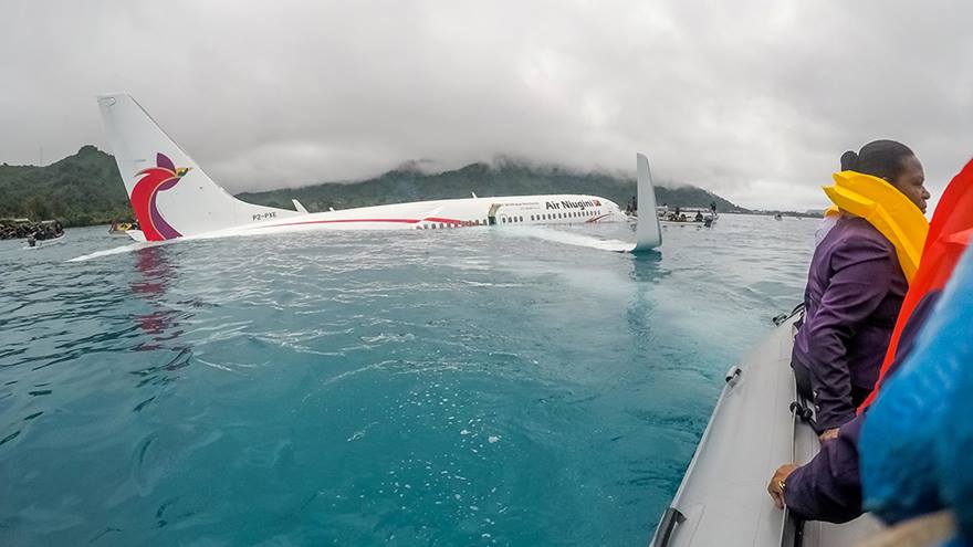 People help after plane has crash-landed in the sea