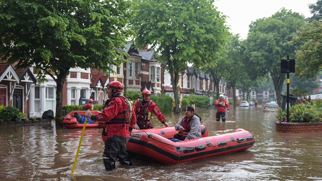 A woman is rescued in a flooded street.