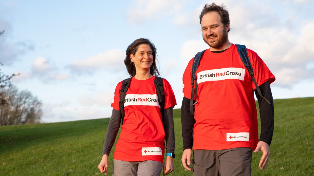 two people enjoy a charity walk outside in British Red Cross tshirts