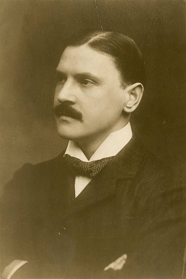 A sepia brown tinted photo of W Somerset Maugham posed for a headshot photo