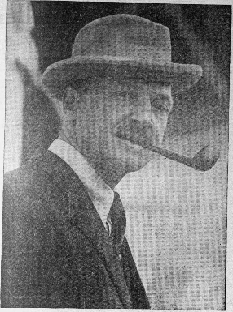 A black and white photo of Maugham taken from a newspaper showing him looking at the camera smoking a pipe.
