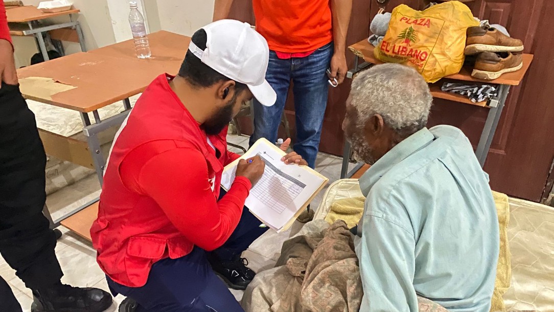 A member of the Dominican Republic Red Cross talks to a patient