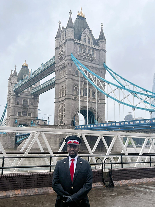 Mohammed stands in front of Tower Bridge, London before King Charles procession.