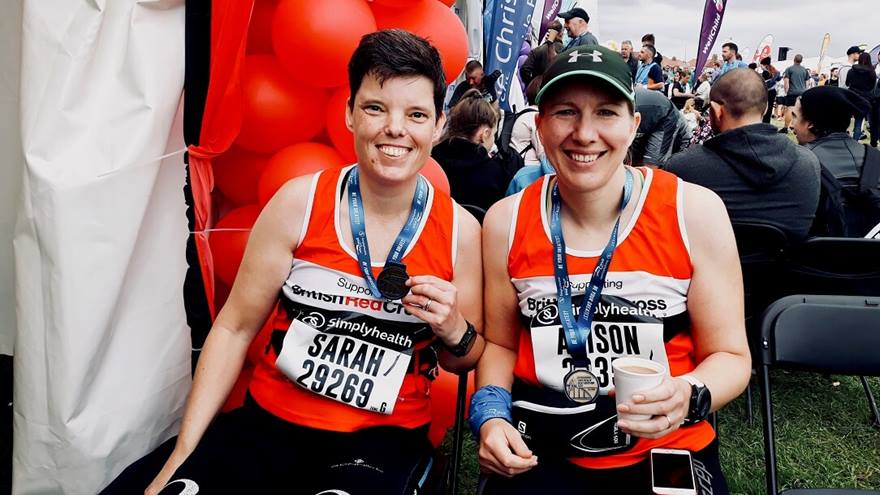 Two women hold their medals after completing the Great North Run