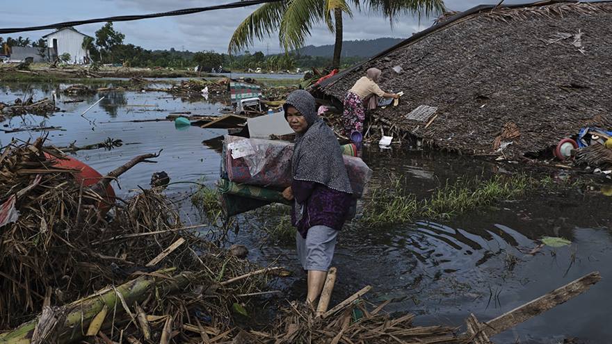 Two women retrieve salvageable items after Tsunami that affected Indonesia in December 2018