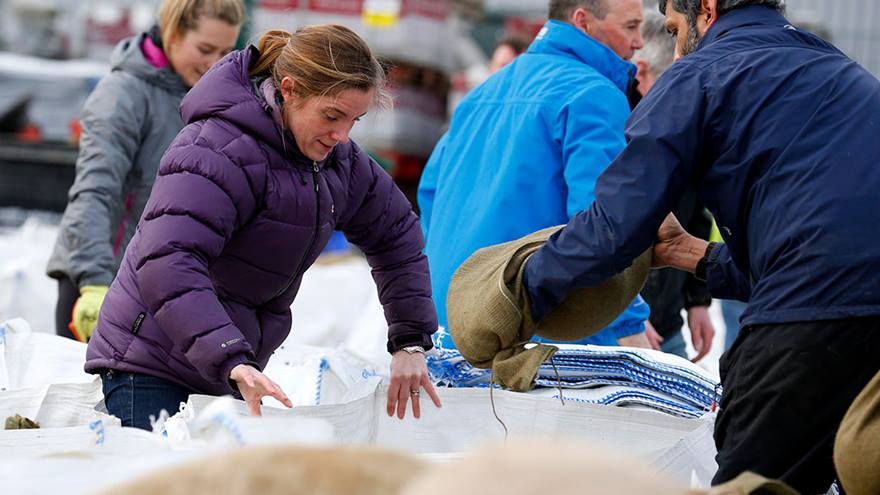 Syrian refugees and other volunteers fill sandbags to stem flood water in York city centre, December 2015.