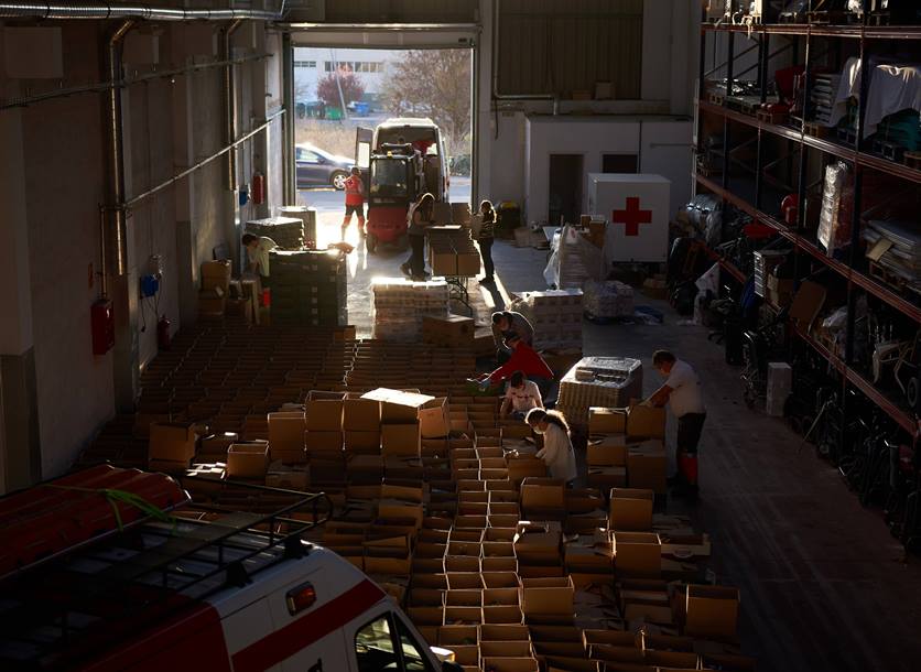 Spanish volunteers in a Red Cross warehouse pack food parcels for people affected by coronavirus.