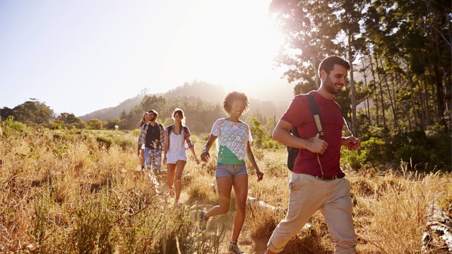 A group of friends walk outside in the hot sun.