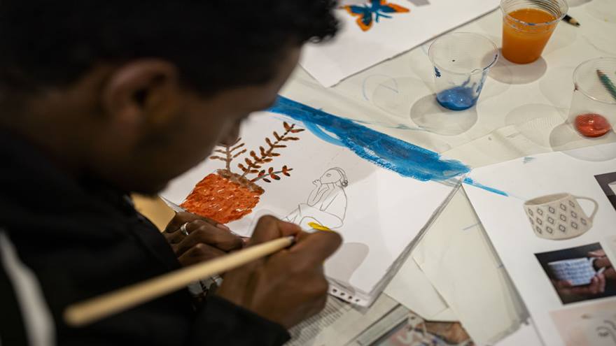 Young person taking part in a refugee art project. The drawing depicts a person sitting down deep in thought.