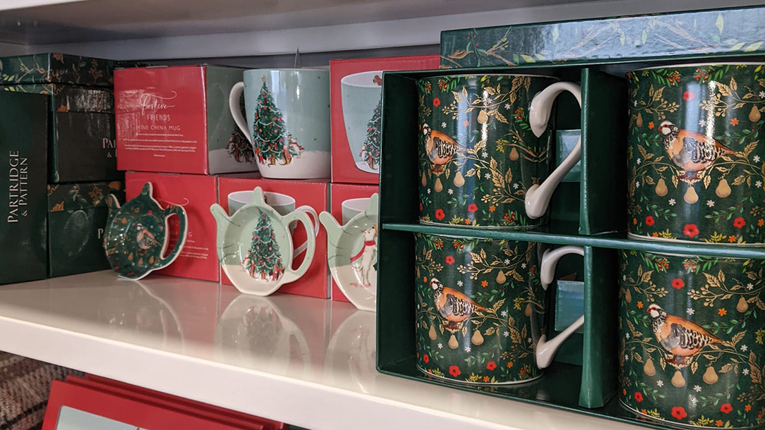 Christmas china on a shelf in a British Red Cross charity shop.