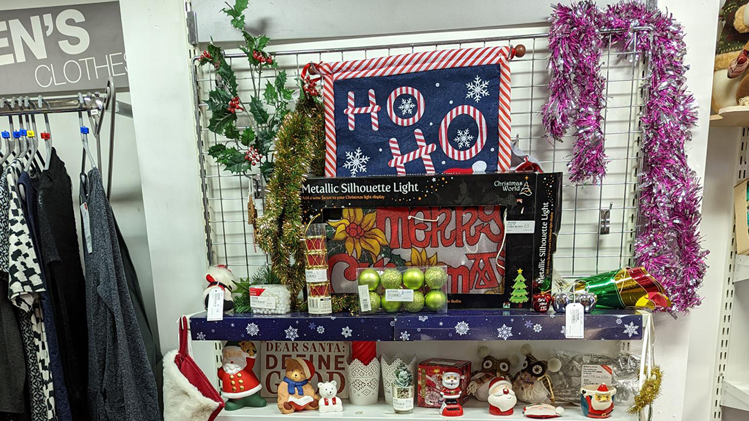 Christmas items on a shelf in a British Red Cross charity shop.