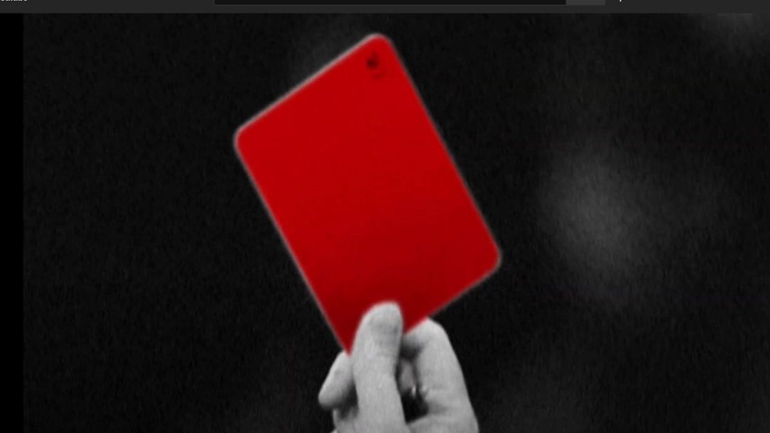 A referee holds up a red card